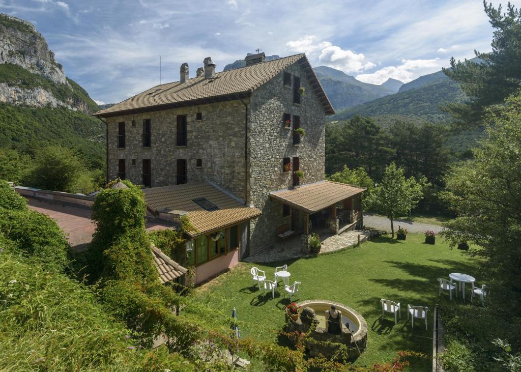 una vista exterior de un gran edificio de piedra con un patio en Hotel de Montaña Uson, en Hecho