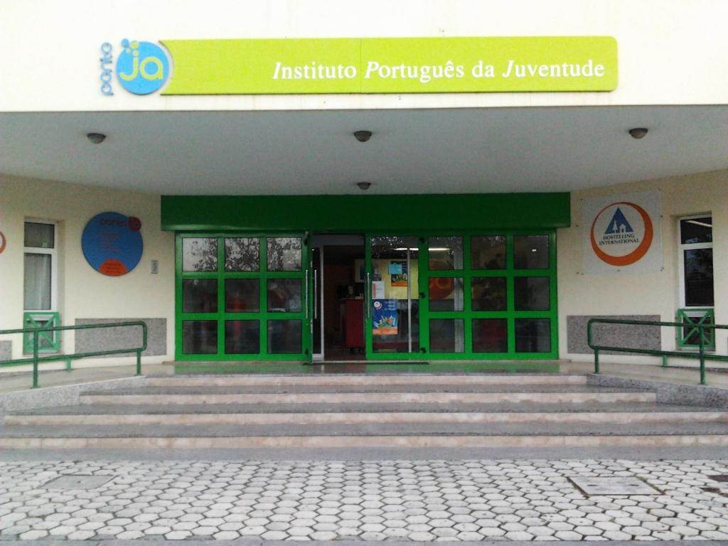 een gebouw met een groene deur en een trap voor de deur bij HI Aveiro – Pousada de Juventude in Aveiro