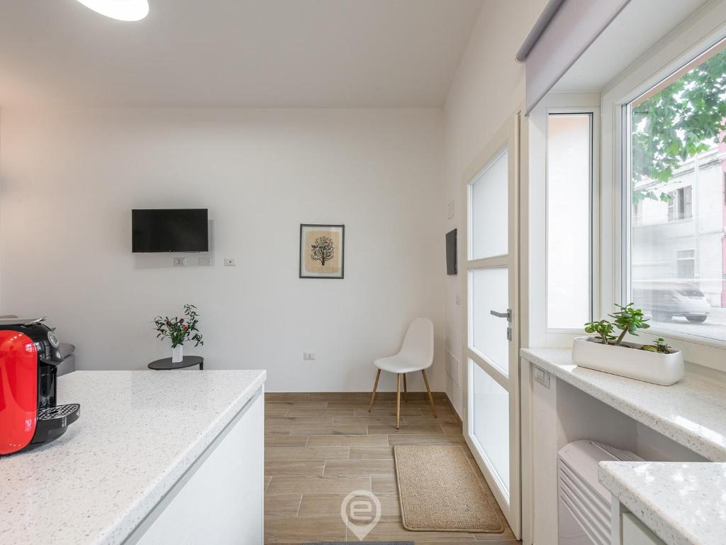 a white kitchen with a desk and a window at Casa Aura - City Centre in Oristano