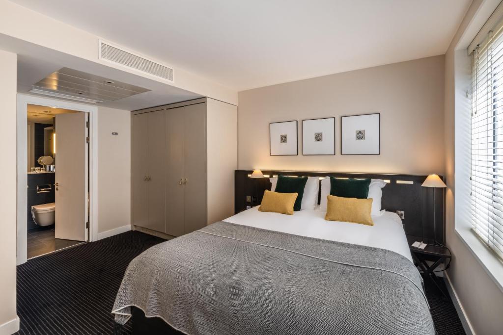 a bedroom with a large white bed with yellow pillows at The Resident Soho in London