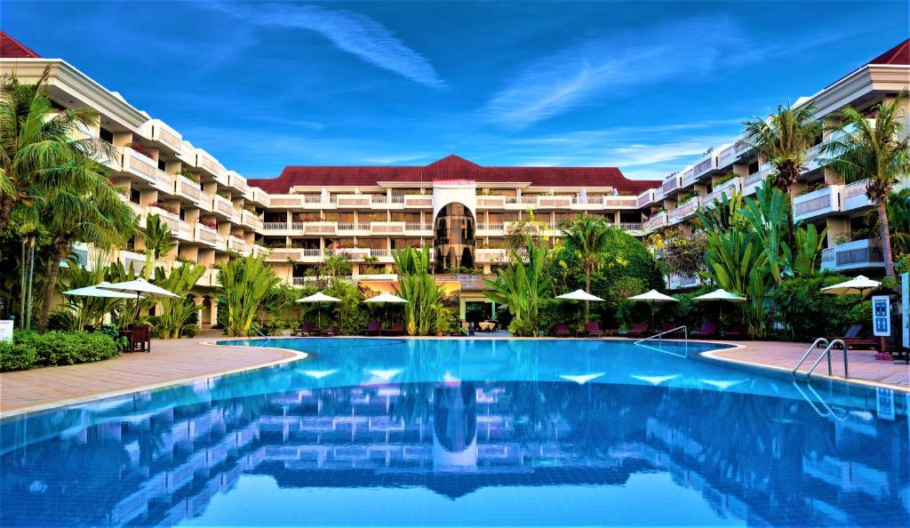 um resort com uma piscina em frente a um edifício em Angkor Century Resort & Spa em Siem Reap