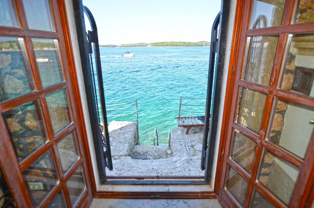 ein offenes Fenster mit Blick auf das Wasser in der Unterkunft Chesa Konoba in Rovinj