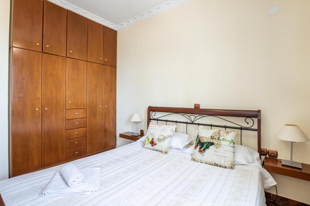 a bedroom with a large white bed with wooden cabinets at Oceanviewvilla in Karpathos