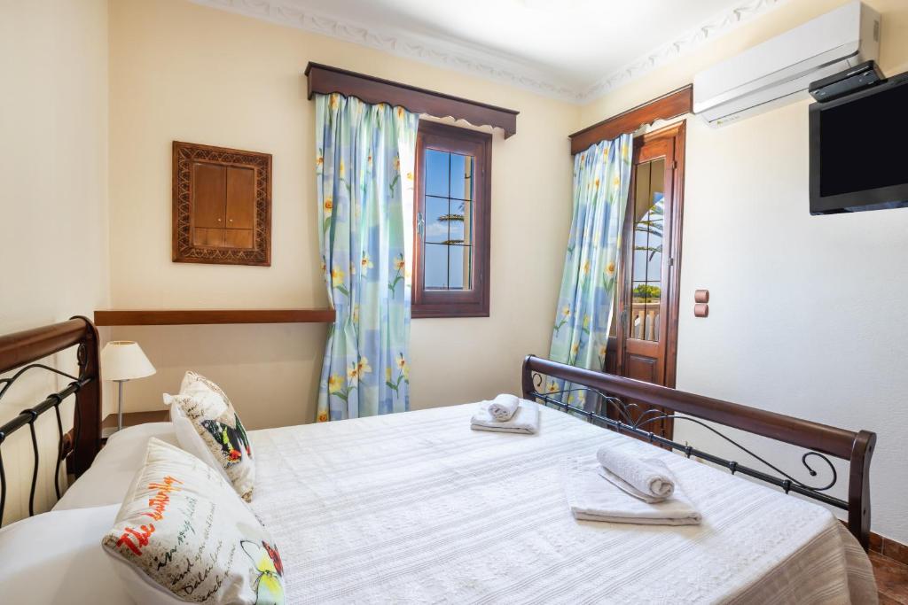 a bedroom with a bed and a tv on the wall at Oceanviewvilla in Karpathos