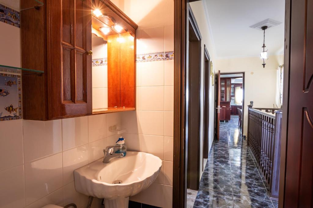 a bathroom with a sink and a mirror and a hallway at Oceanviewvilla in Karpathos
