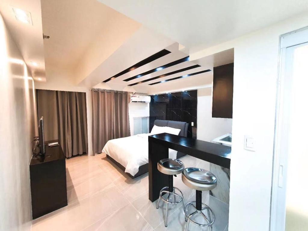 a hotel room with a bed and a black counter at Burgundy McKinley Place Service Apartment in Manila