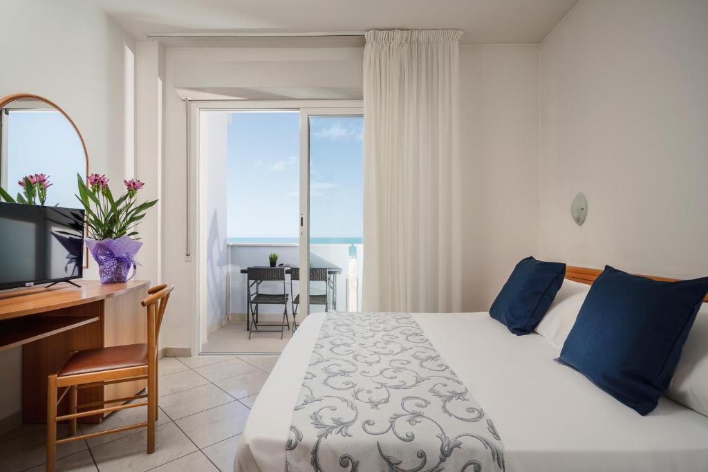 - une chambre avec un lit, un bureau et une fenêtre dans l'établissement Residence Hotel Piccadilly, à Rimini