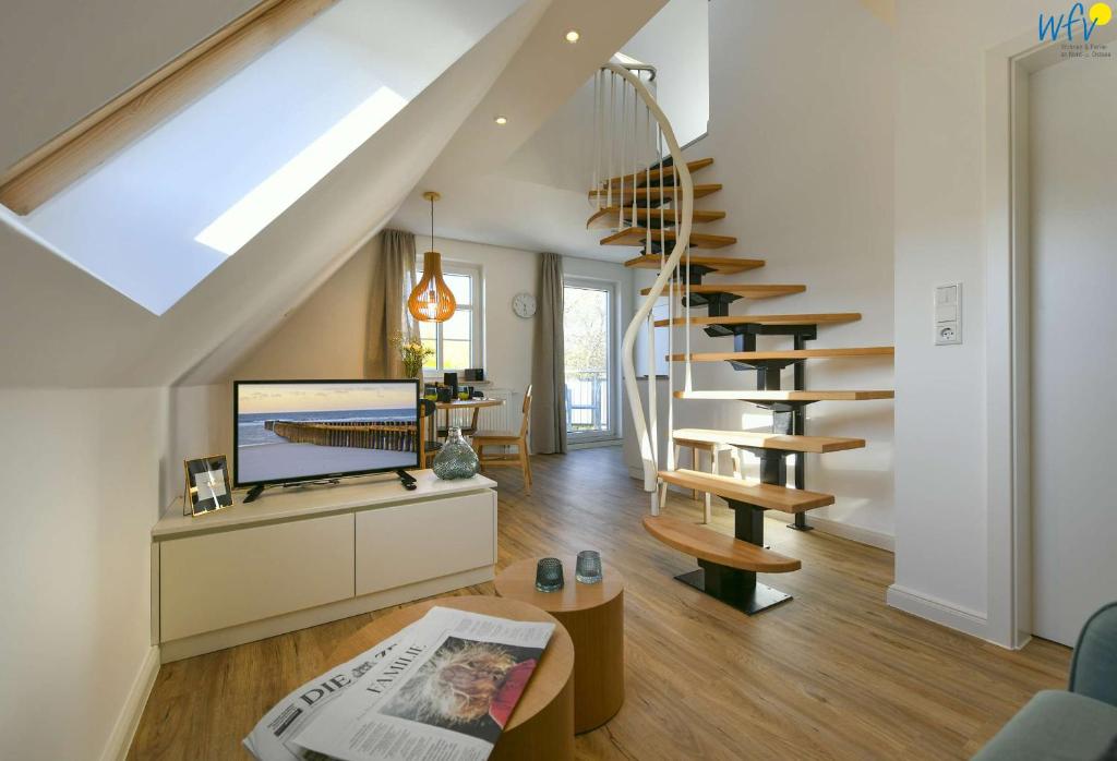 un salon avec un escalier en colimaçon et un journal dans l'établissement Haus am Dorfbrunnen Ferienwohnung Meer, à Wangerooge