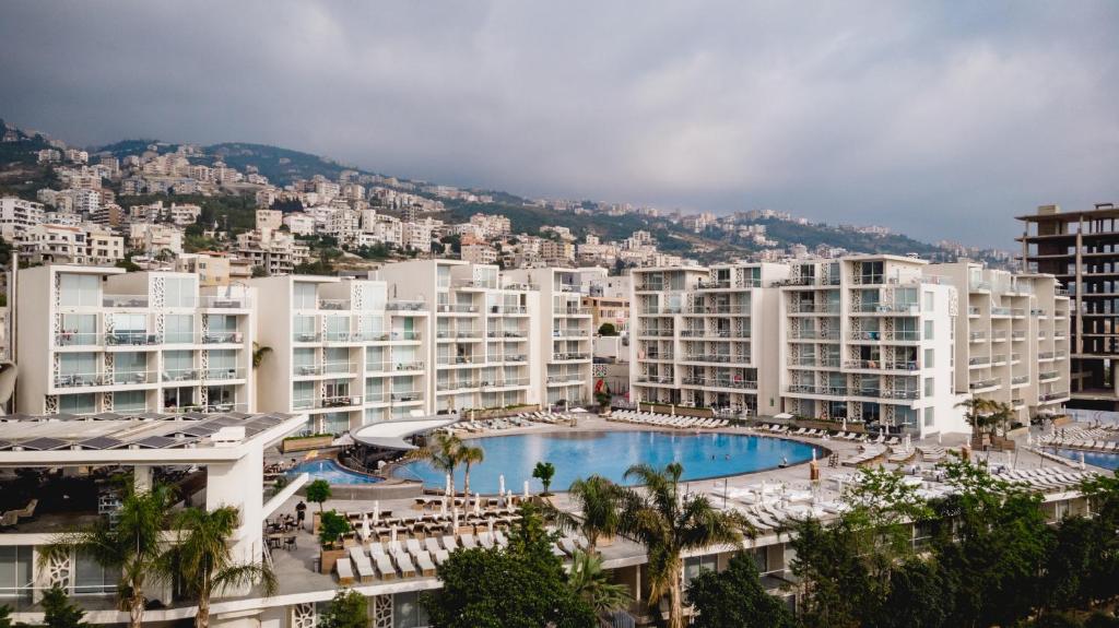 a large apartment complex with a swimming pool and buildings at WhiteLace Resort in Jbeil