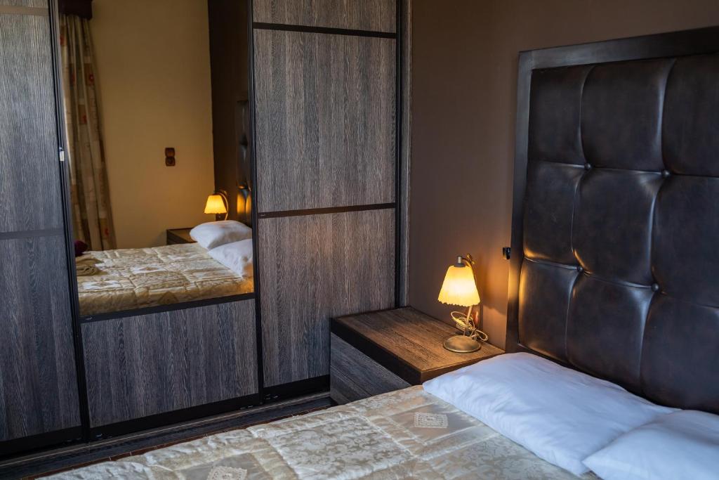 a bedroom with two beds and a mirror and a bed sidx sidx sidx at Oceanviewvilla in Karpathos