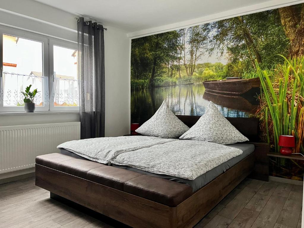 a bedroom with a large painting of a lake at Kahnstübchen in Lübben