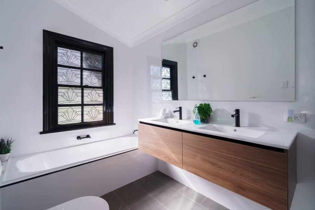 a bathroom with a sink and a tub and a window at Bryn-y-Mor Cottage Romantic Fireplace Couples in Leura