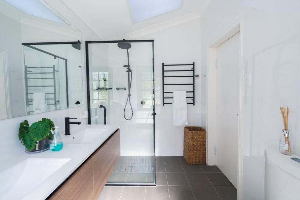 a white bathroom with a shower and a sink at Bryn-y-Mor Cottage Romantic Fireplace Couples in Leura