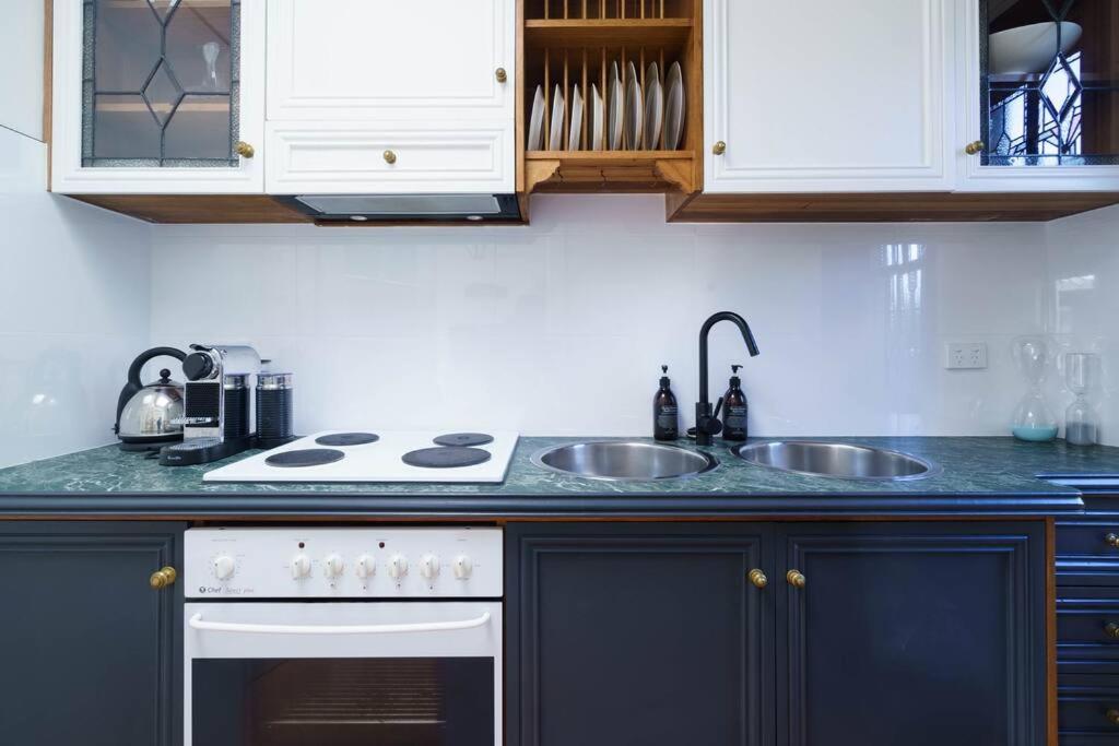 a kitchen with a white stove and a sink at Bryn-y-Mor Cottage Romantic Fireplace Couples in Leura