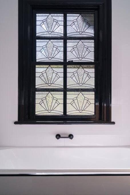 a window in a white wall with a window sidx sidx sidx at Bryn-y-Mor Cottage Romantic Fireplace Couples in Leura