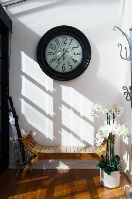 a clock hanging on a wall next to a bench at Bryn-y-Mor Cottage Romantic Fireplace Couples in Leura