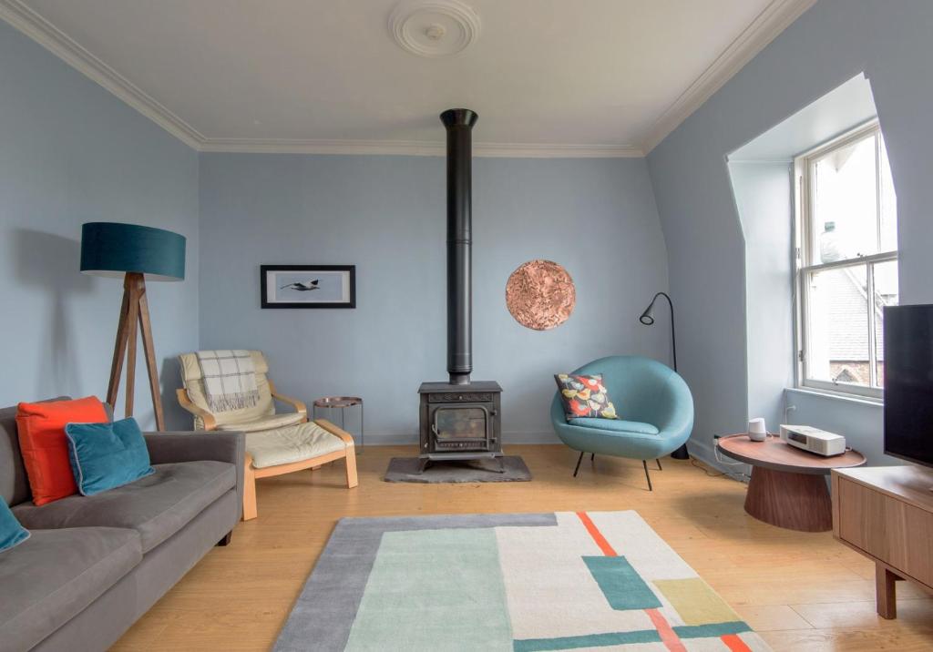 a living room with a couch and a stove at Rooftops in North Berwick