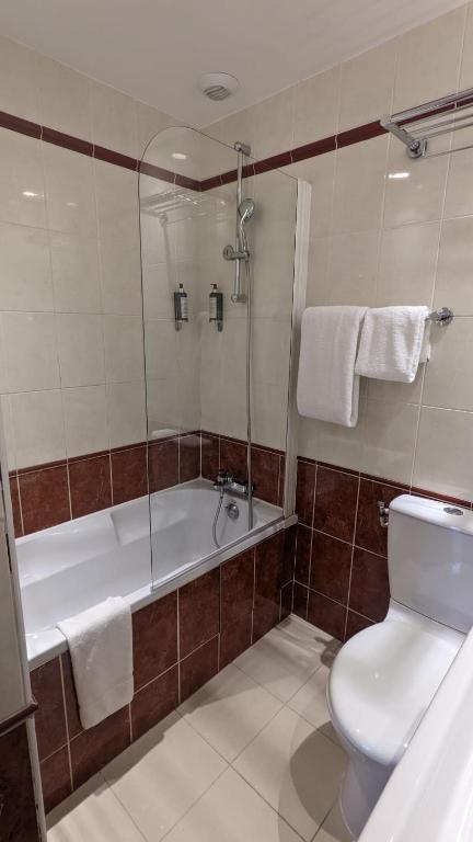 a bathroom with a tub and a toilet and a shower at Magda Champs Elysées in Paris