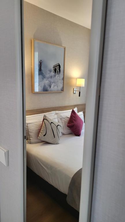 a bedroom with a bed with two pillows on it at Magda Champs Elysées in Paris