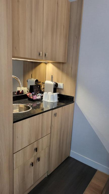 a kitchen with wooden cabinets and a sink at Magda Champs Elysées in Paris