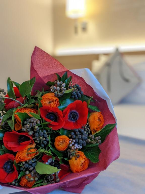 a bouquet of red flowers on a pink paper at Magda Champs Elysées in Paris