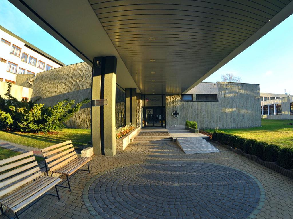 a building with two benches in front of it at Dobre Miejsce Dom Rekolekcyjny in Warsaw