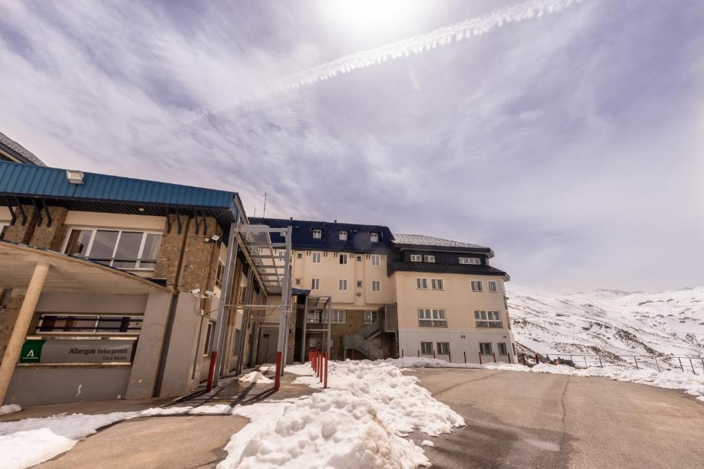 un grupo de edificios en una calle cubierta de nieve en Albergue Inturjoven Sierra Nevada, en Sierra Nevada