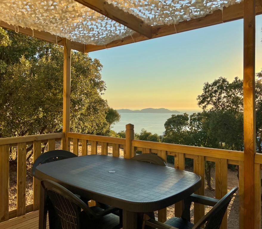 una mesa en una terraza con vistas al océano en Roccapina, en Lumio