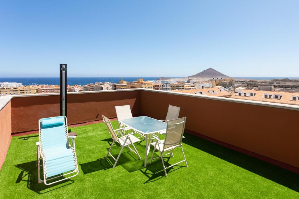 eine Terrasse mit einem Tisch und Stühlen auf dem Dach in der Unterkunft Home2Book Duplex El Medano Pool & Terrace in El Médano