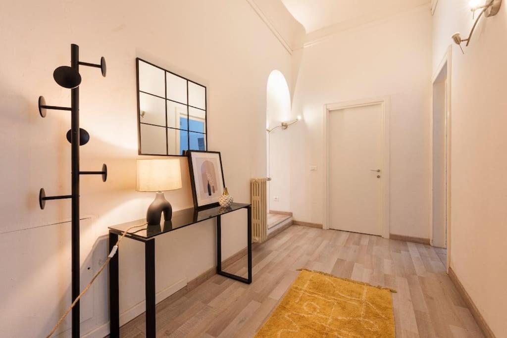Cette chambre comprend une table avec une lampe et un miroir. dans l'établissement Apartments Florence-4 bedroom in Pellicceria (sx), à Florence
