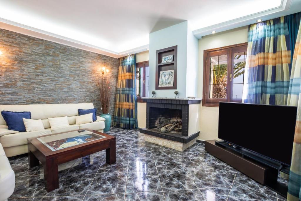 a living room with a couch and a fireplace at Oceanviewvilla in Karpathos