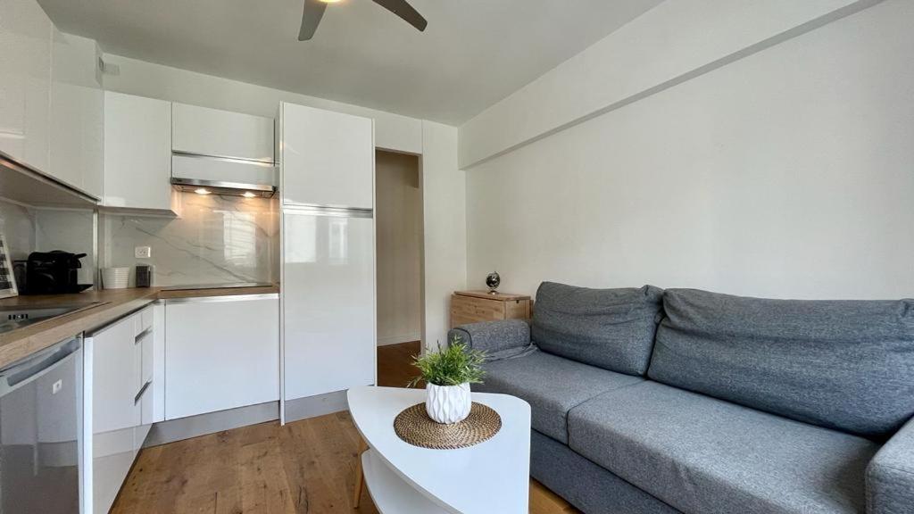 ein Wohnzimmer mit einem Sofa und einer Küche in der Unterkunft Superbe 2 Pièces à cannes plage Festival ! in Cannes