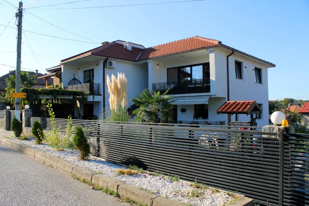 une maison avec une clôture devant elle dans l'établissement Belov Rooms and Apartments, à Demir Kapiya