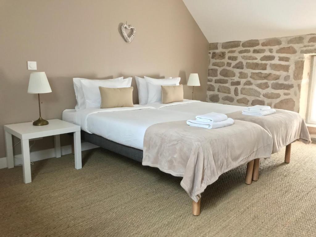 sypialnia z dużym łóżkiem i kamienną ścianą w obiekcie Gîtes Le Fer A Cheval Vassivière w mieście Royère-de-Vassivière