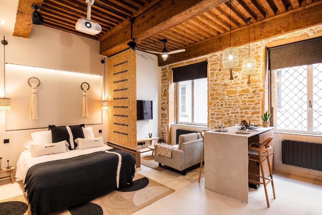 a bedroom with a bed and a desk and a chair at Host Inn Le Lumiere SPA & CINÉMA in Lyon