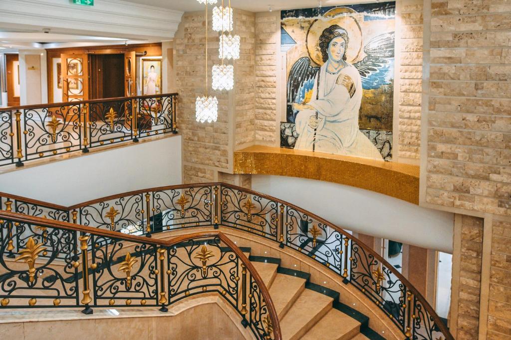a spiral staircase in a building with a painting on the wall at A Hoteli - Hotel Izvor in Arandelovac