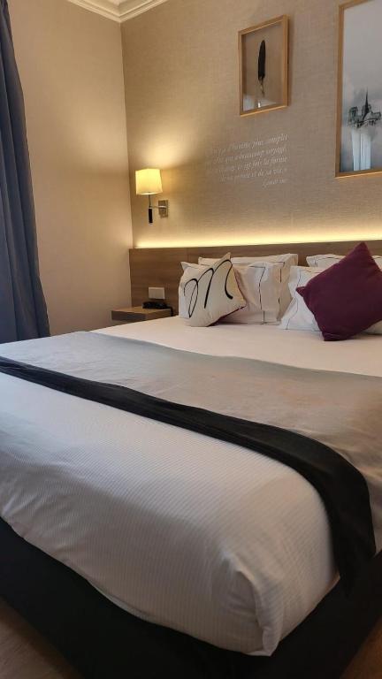 a large white bed in a hotel room at Magda Champs Elysées in Paris