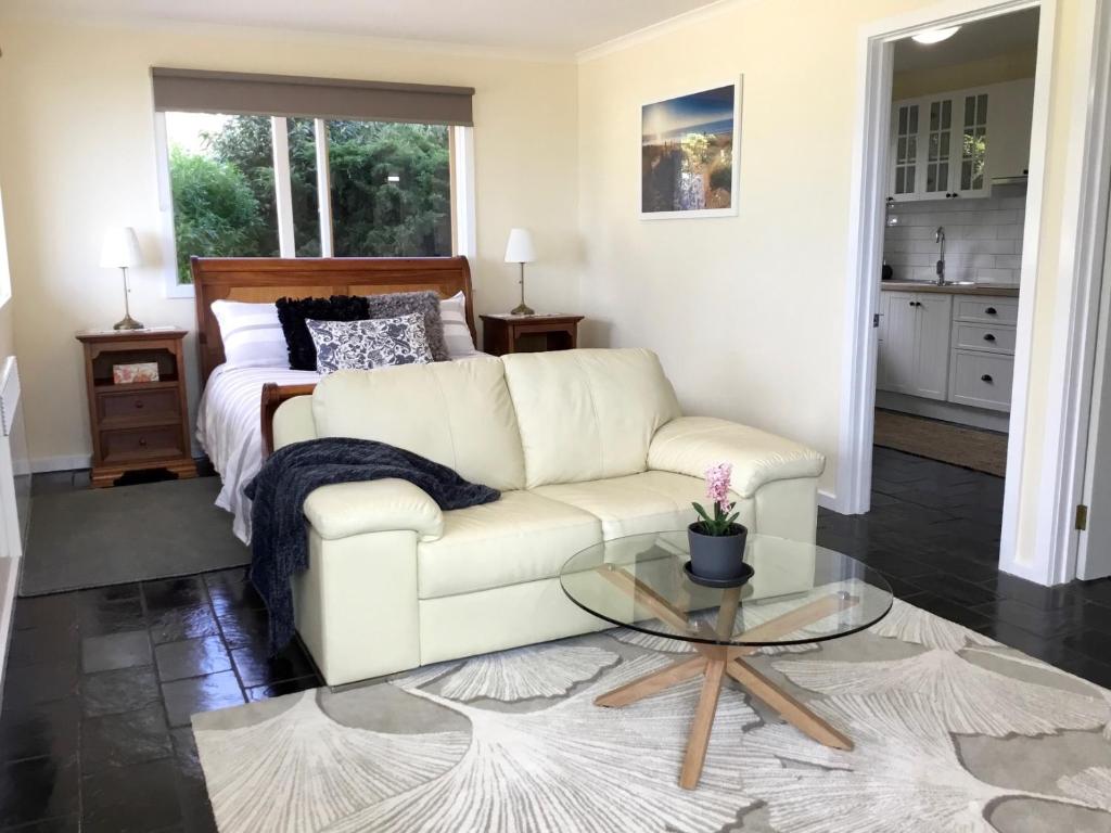 a living room with a white couch and a bed at Skyescape on Northshore in Table Cape