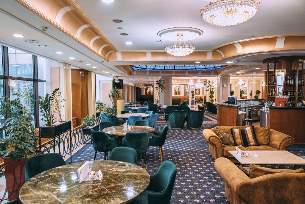 a lobby of a hotel with tables and chairs at A Hoteli - Hotel Izvor in Arandelovac