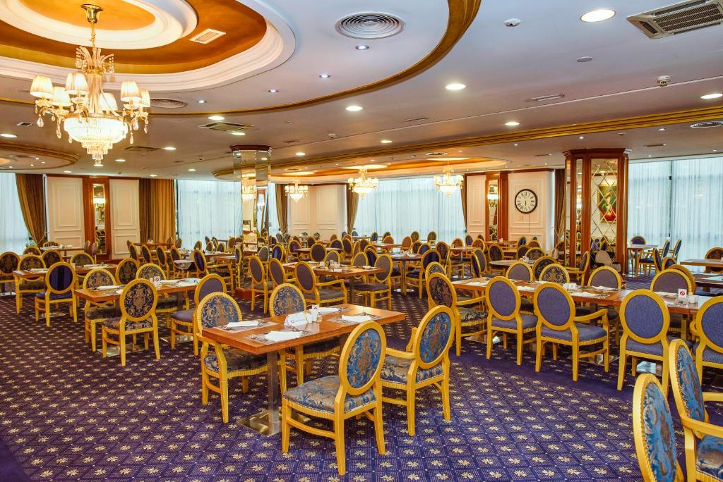 a restaurant with tables and chairs in a room at A Hoteli - Hotel Izvor in Arandelovac