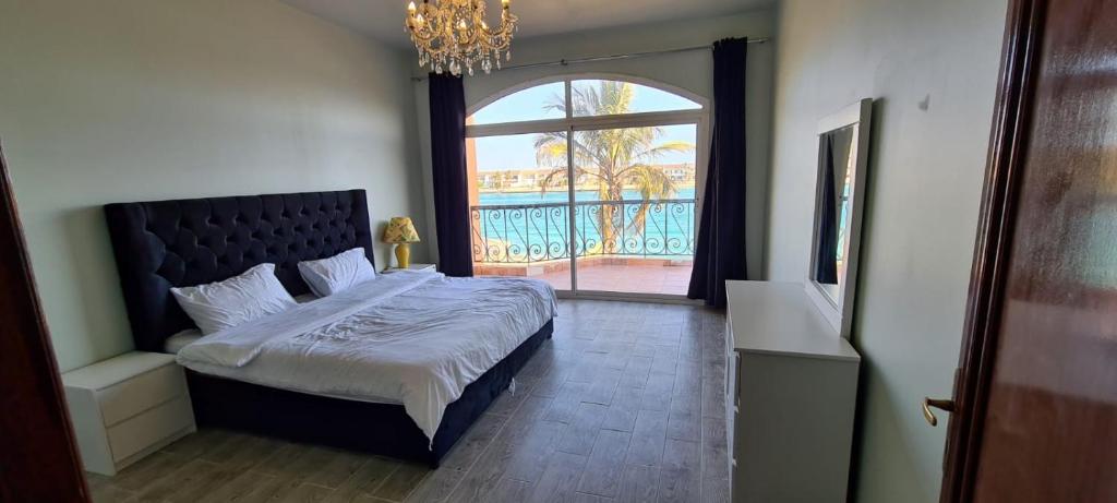 a bedroom with a bed and a large window at فيلا بمسبح خاص درة العروس in Durat Alarous