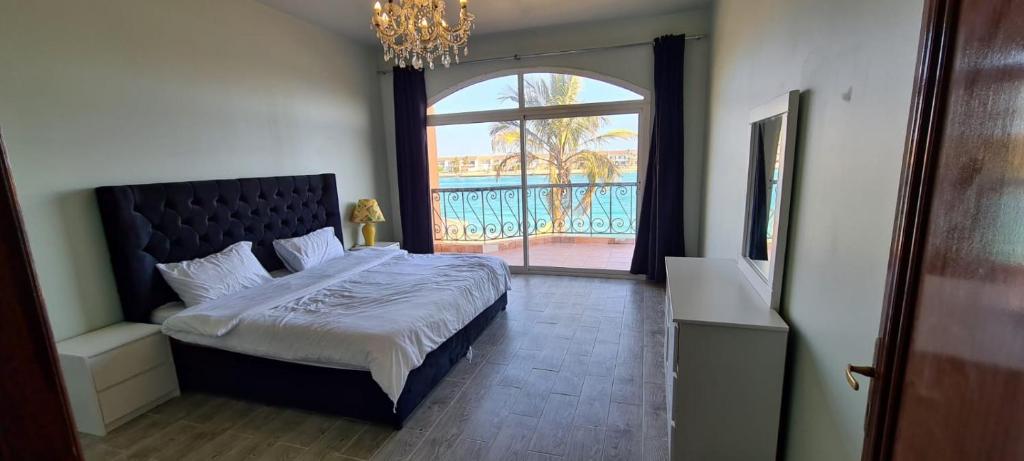 a bedroom with a bed and a large window at فيلا بمسبح خاص درة العروس in Durat  Alarous
