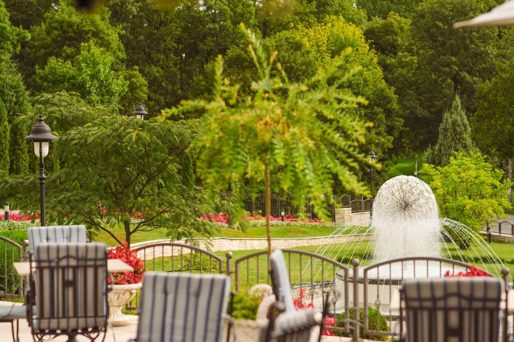a fountain in a park with chairs and a fountain at A Hoteli - Hotel Izvor in Arandelovac