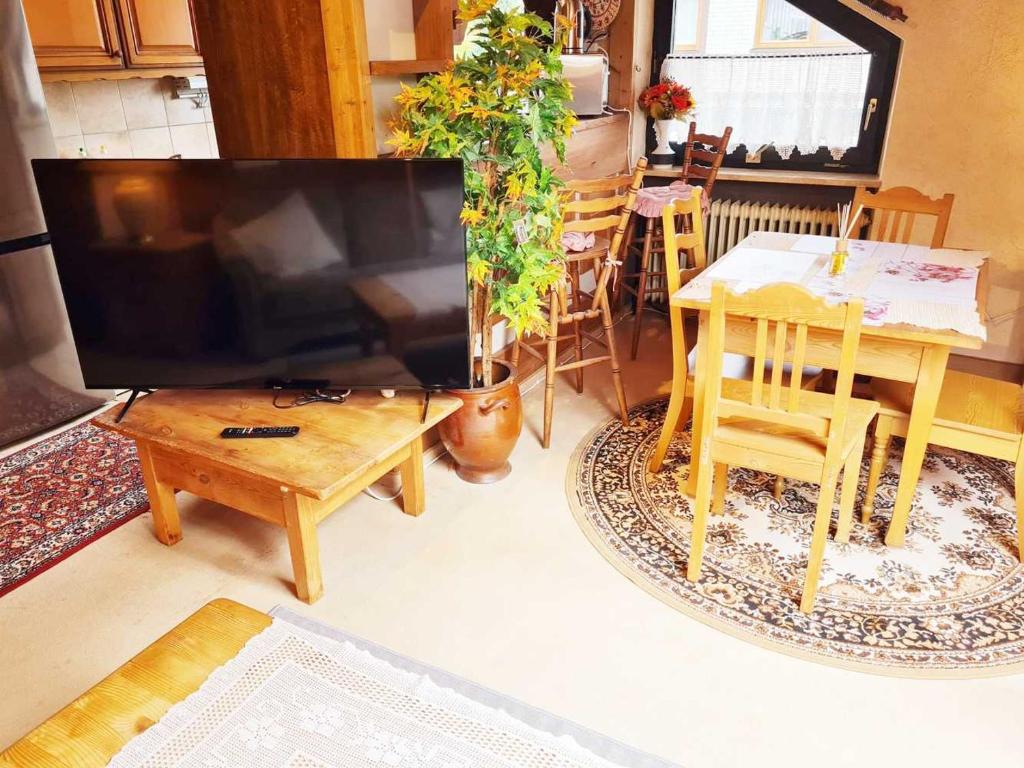 ein Wohnzimmer mit einem großen TV und einem Tisch in der Unterkunft Calm located Penthouse in Langenloh in Petersaurach