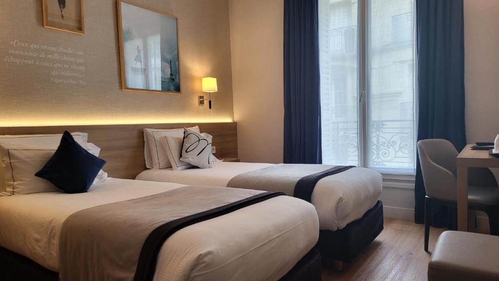 a hotel room with two beds and a window at Magda Champs Elysées in Paris
