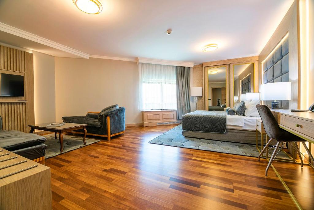 a bedroom with a bed and a living room at A Hoteli - Hotel Izvor in Arandelovac