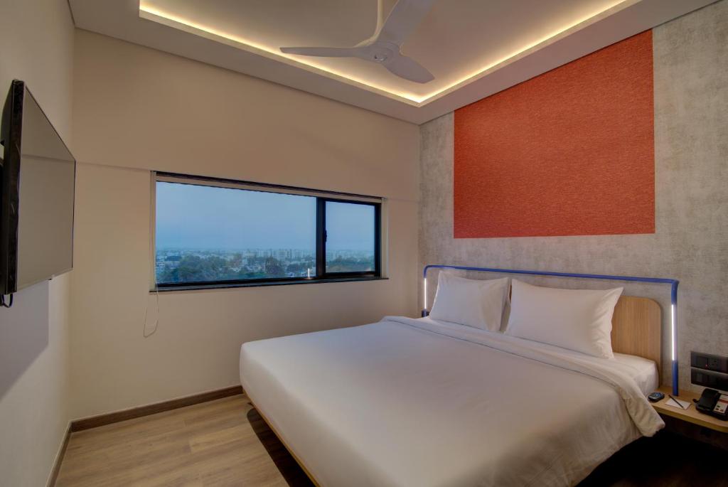 Postel nebo postele na pokoji v ubytování 7 Apple Hotel Nashik
