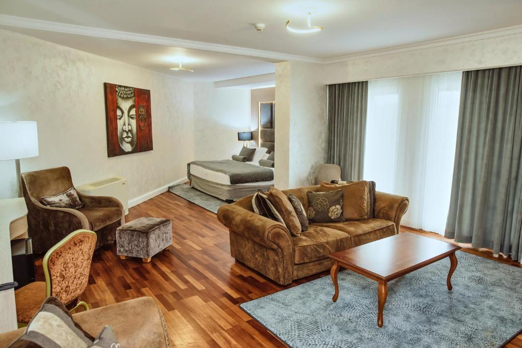 a living room with a couch and a bed at A Hoteli - Hotel Izvor in Arandelovac