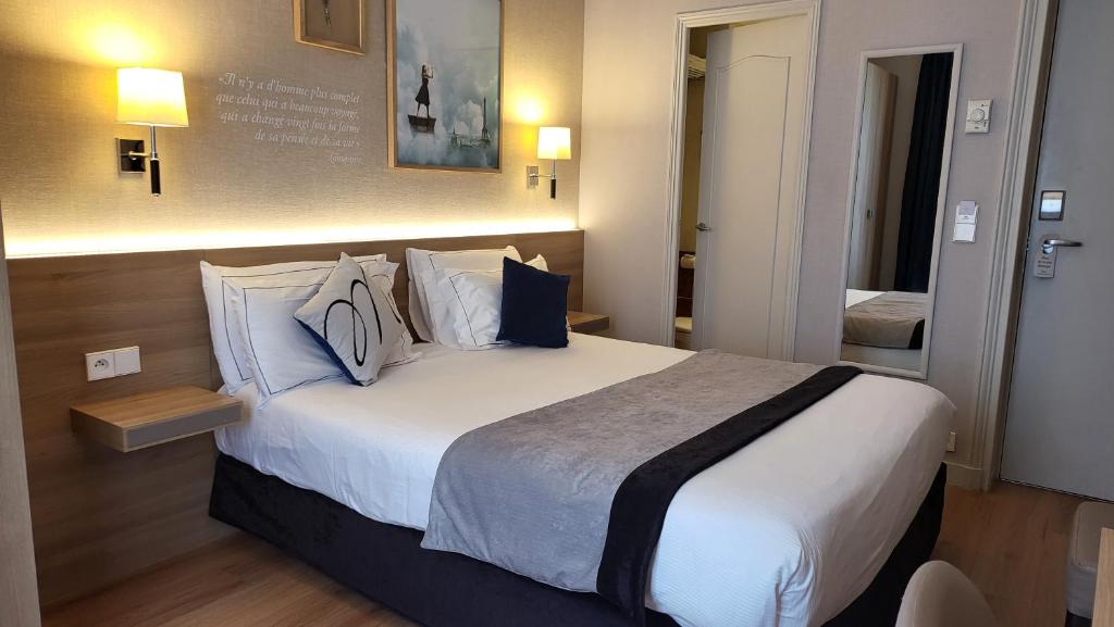 a hotel room with a large bed with pillows at Magda Champs Elysées in Paris