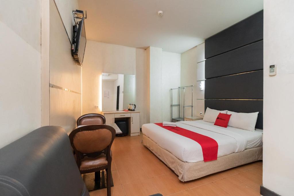 a hotel room with a bed and a chair at RedDoorz at Jalan Gunung Sahari in Jakarta